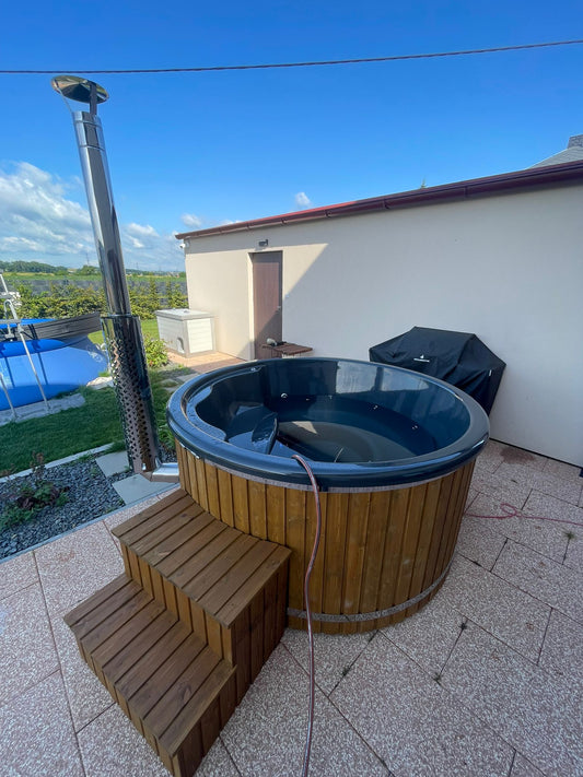 200 cm round fiberglass hot tub with integrated wood-fired heater, wooden steps and dark fiberglass shell