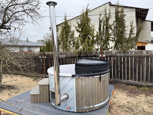 200 cm round fiberglass hot tub with integrated wood-fired heater, chimney, wooden steps and half-open insulated cover, side view