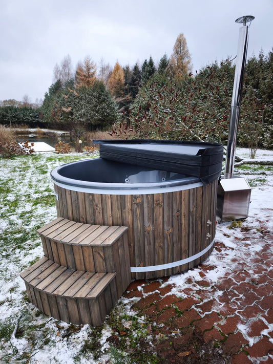 200 cm round fiberglass hot tub with pearl finish, external wood-fired heater, wooden steps and half-open insulated cover, front angle view